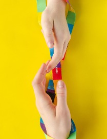 two hands with colourful ribbon